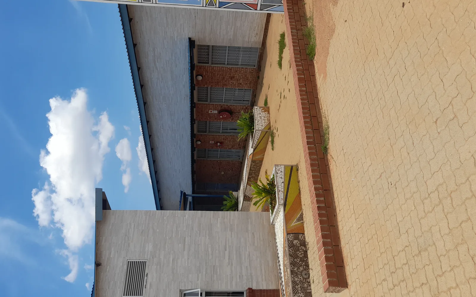Modern library building exterior with concrete walls and glass elements against blue sky